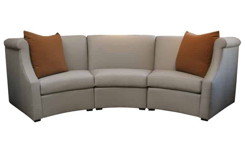 The Dara Sectional, by Vicente Wolf. A three-cushion curved sofa with tapered arms. Upholstered in ecru fabric.